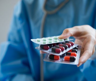 Woman pharmacist holding prescription medicine from doctor order